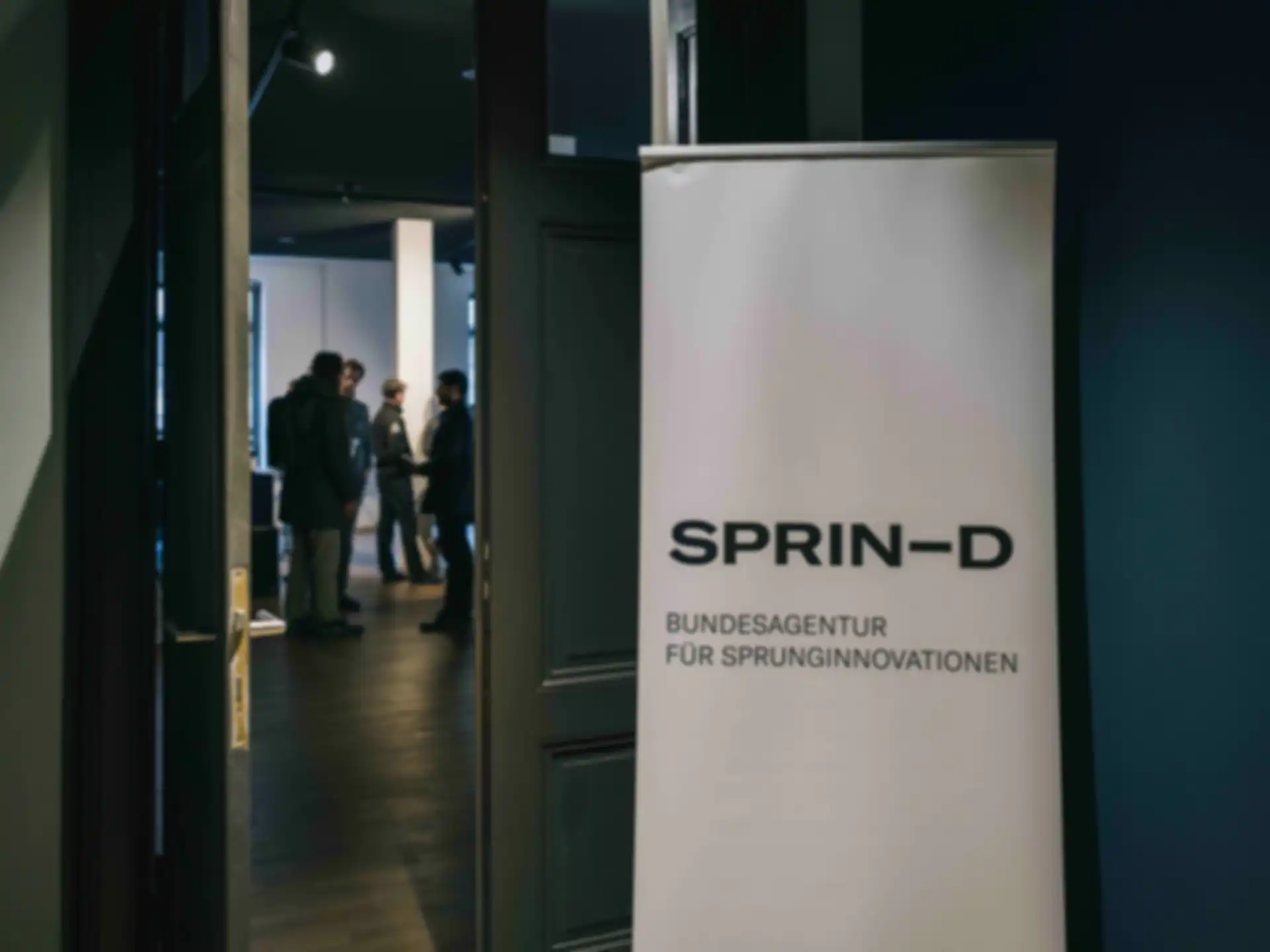 A "SPRIND" banner in the hallway of the event venue.
