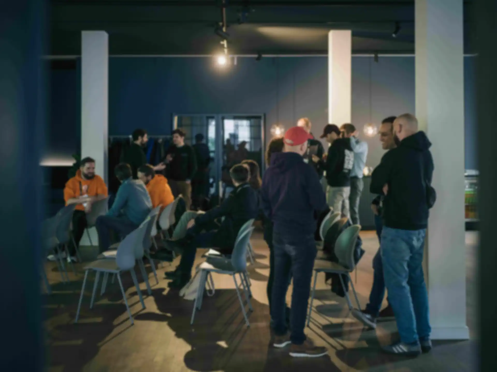 Several groups of people are chatting throughout the room.