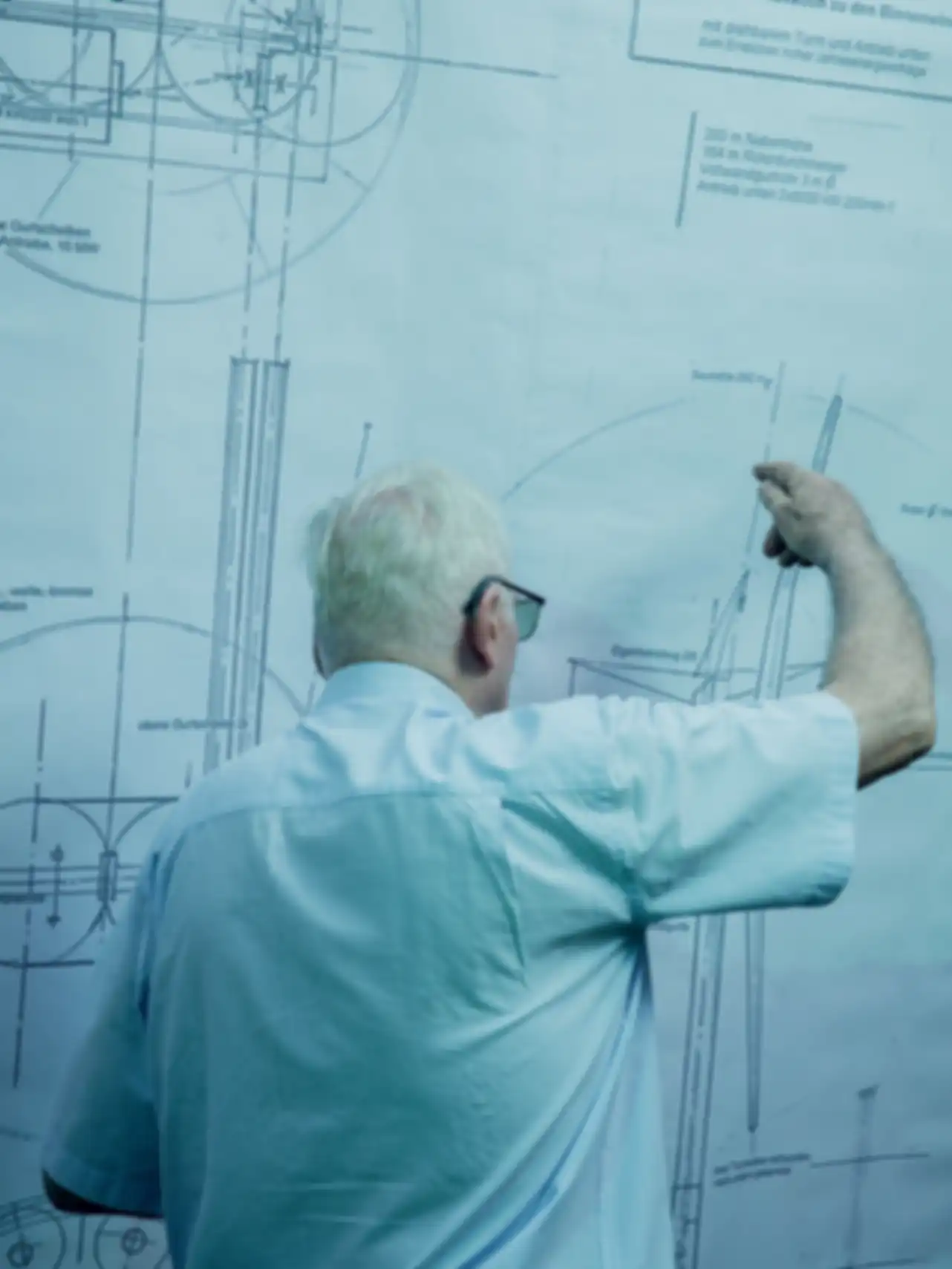 Portraif Horst Bendix vor einer technischen Zeichnung