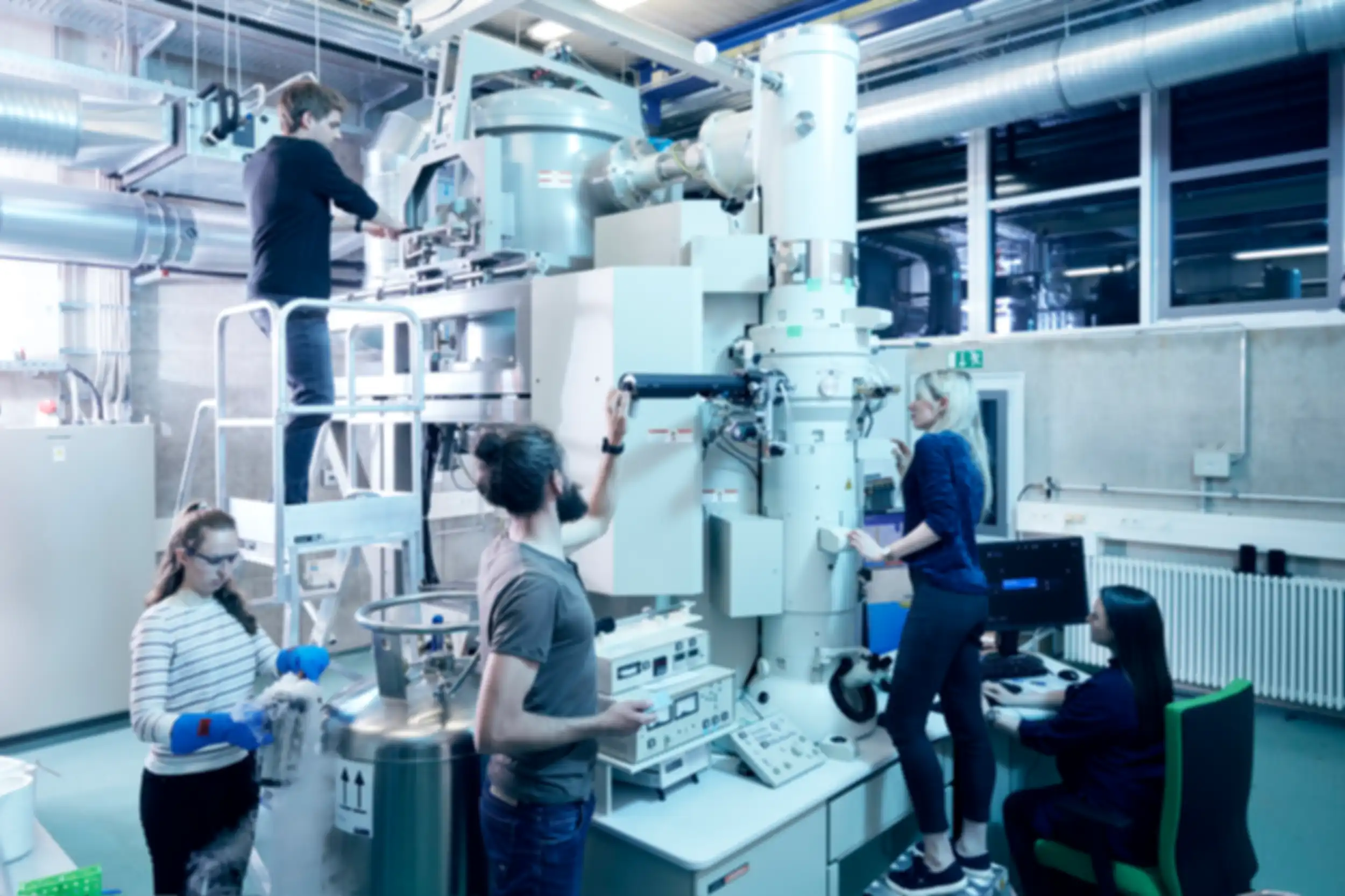 Several people are standing scattered around a large piece of equipment