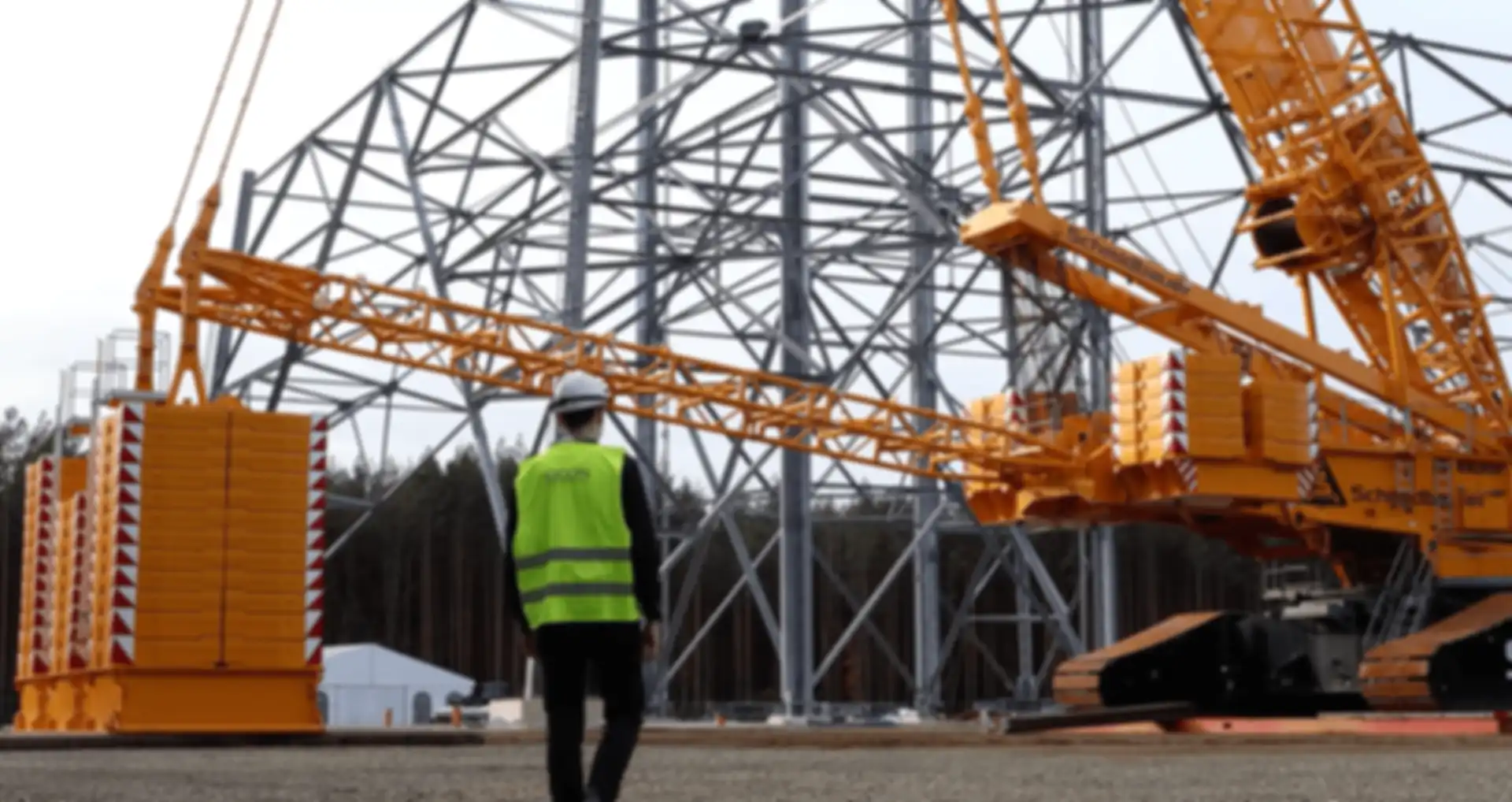Norio in front of a high-altitude wind turbine under construction