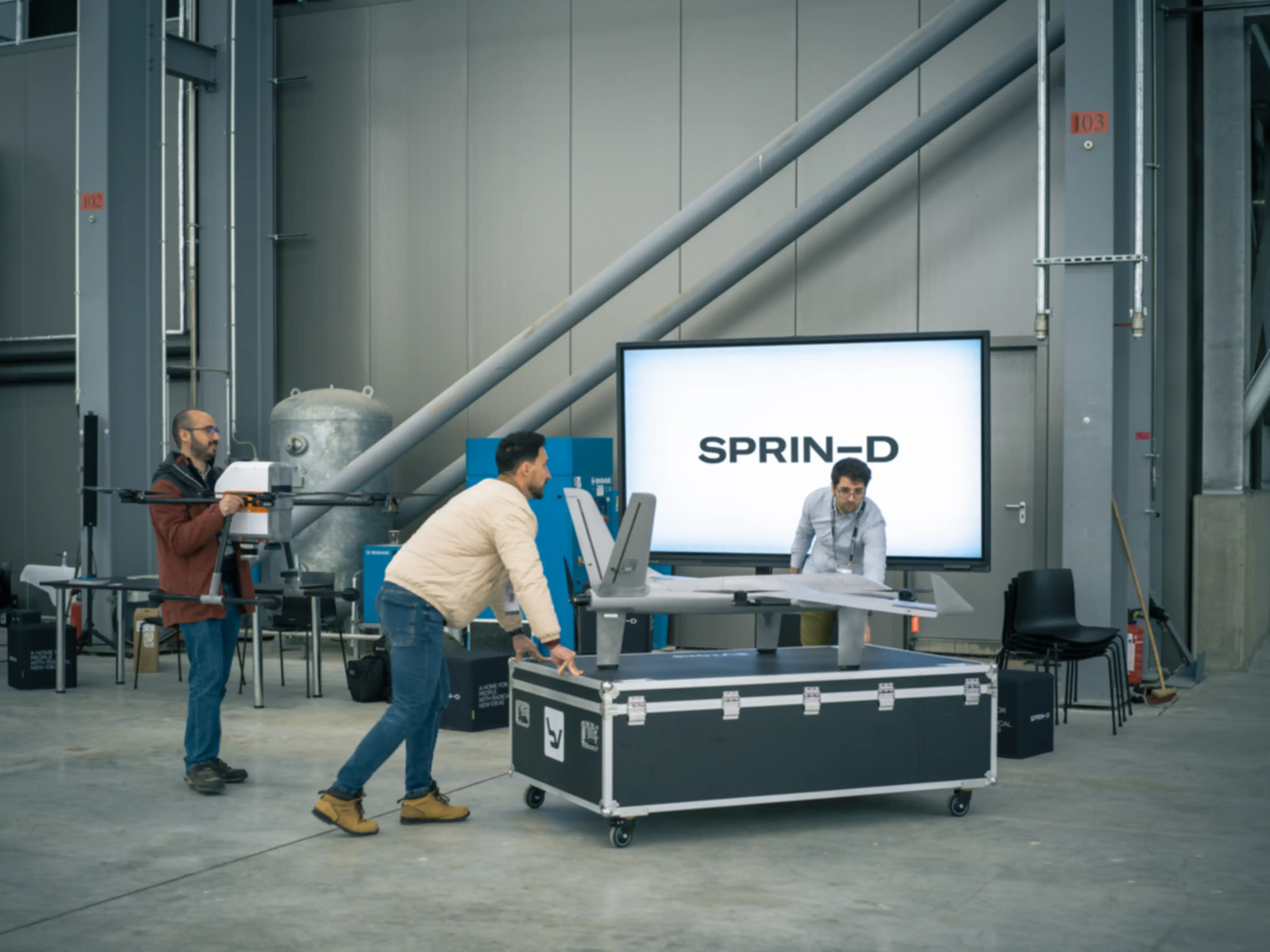 In a hangar, a team is preparing its drone