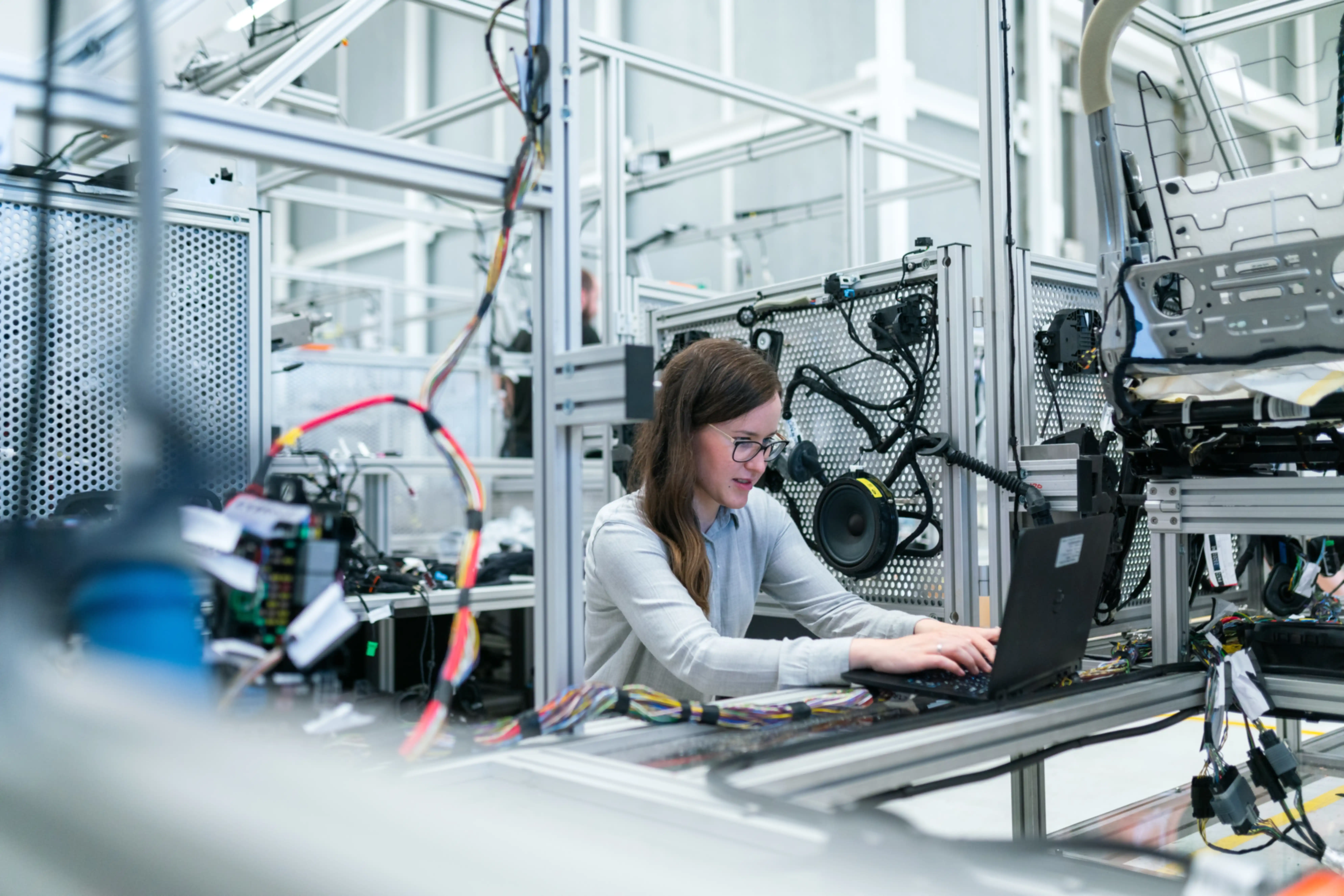 Eine Frau an einem Laptop in einer Fabrik